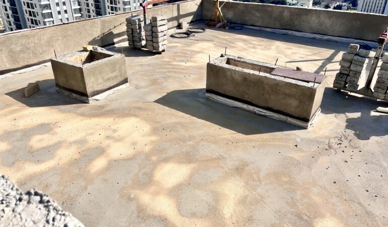 Dam istənilən tikilinin ən vacib qoruyucu hissələrindən biridir. Yağış, qar, günəş şüaları və temperatur fərqləri birbaşa dam səthinə təsir etdiyi üçün burada edilən ən kiçik səhv belə gələcəkdə böyük xərcə səbəb ola bilər. Məhz buna görə dam izolyasiyası layihəsi sadəcə texniki iş deyil, obyektin uzunömürlülüyünə verilən strateji qərardır. Keyfiyyətli dam izolyasiyası ilk növbədə su sızmasının qarşısını alır. Lakin məsələ yalnız bununla bitmir. Düzgün qurulmuş izolyasiya sistemi beton qatların, metal elementlərin və daxili örtüklərin vaxtından əvvəl zədələnməsinin qarşısını alır. Bu isə həm təmir xərclərini azaldır, həm də tikilinin ümumi dayanıqlığını artırır. Layihəyə başlamazdan əvvəl damın mövcud vəziyyəti dəqiq təhlil olunmalıdır. Səthdə çatlar, köhnə örtük problemləri, suyun toplanma nöqtələri və daşıyıcı hissələrin vəziyyəti yoxlanılmadan görülən işlər sonradan effektiv nəticə vermir. Peşəkar yanaşma məhz diaqnostika ilə başlayır. Bundan sonra isə səthə uyğun material və tətbiq üsulu seçilir. Dam izolyasiyasında istifadə olunan materialın keyfiyyəti nəticənin əsasını təşkil edir. Keyfiyyətsiz və ya yanlış seçilmiş məhsullar qısa müddətdə deformasiya ola, elastikliyini itirə və sızmalara səbəb ola bilər. Buna görə layihələrdə etibarlı və sınaqdan keçmiş məhsullardan istifadə edilməsi vacibdir. Xüsusilə peşəkar sistem həlləri layihənin daha dayanıqlı və təhlükəsiz icrasına imkan yaradır. Damla İnşaat olaraq dam izolyasiyası layihələrinə yalnız tətbiq işi kimi yox, bütöv sistem həlli kimi yanaşırıq. Məqsədimiz müştəriyə qısa müddətli görüntü deyil, uzun illər davam edən nəticə təqdim etməkdir. Hər layihədə obyektin xüsusiyyəti, iqlim təsirləri, istifadə təyinatı və texniki tələblər nəzərə alınır. Nəticə etibarilə, dam izolyasiyası gələcək risklərin qarşısını bu gündən almaq deməkdir. Düzgün planlama, keyfiyyətli material və peşəkar tətbiq bir araya gəldikdə həm bina qorunur, həm də sahibkar əlavə xərclərdən yayınmış olur. Etibarlı dam, etibarlı layihə ilə başlayır.